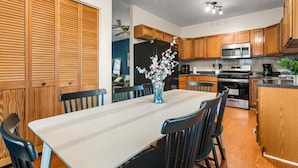 A modern kitchen with wooden cabinets, a stainless steel refrigerator, a microwave, and a coffee maker. - 
Spacious 4BR Townhouse  Sleeps 13  Near DC&Metro (Arlington)