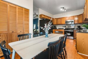 A modern kitchen with wooden cabinets, a stainless steel refrigerator, a microwave, and a coffee maker. - 
Spacious 4BR Townhouse  Sleeps 13  Near DC&Metro (Arlington)