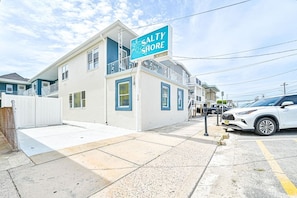 A two-story building with a sign reading 'SALTY SHORE' and a gated driveway. - Salty Shore Retreat: Idyllic Studio by the Sea (Wildwood)