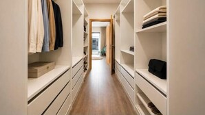A narrow hallway with built-in closets on either side, leading to an open door at the end. - Luxury apartment with ocean views and a pool | Air conditioning | 2 suites (Albufeira)