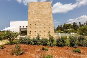 A modern building with a tall, rectangular tower and a white structure with large windows. - Ultra-Lux Tower Villa: Dual Pools, Near Beaches (Gallipoli)