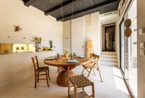 A dining area with a round table, four chairs, and a kitchen visible in the background. - Ultra-Lux Tower Villa: Dual Pools, Near Beaches (Gallipoli)