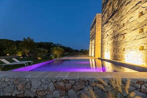A swimming pool with stone walls and a stone deck in front. - Ultra-Lux Tower Villa: Dual Pools, Near Beaches (Gallipoli)