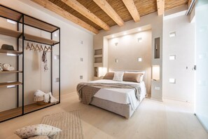 Ein Schlafzimmer mit Bett, Nachttischen, einem Kleiderschrank und einem Spiegel.