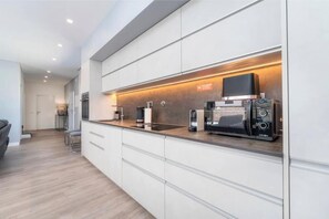 A modern kitchen with white cabinetry, a built-in oven, and a coffee machine. - Villa with private pool | 3 bedrooms, 2 en suite | Air conditioning (Albufeira)