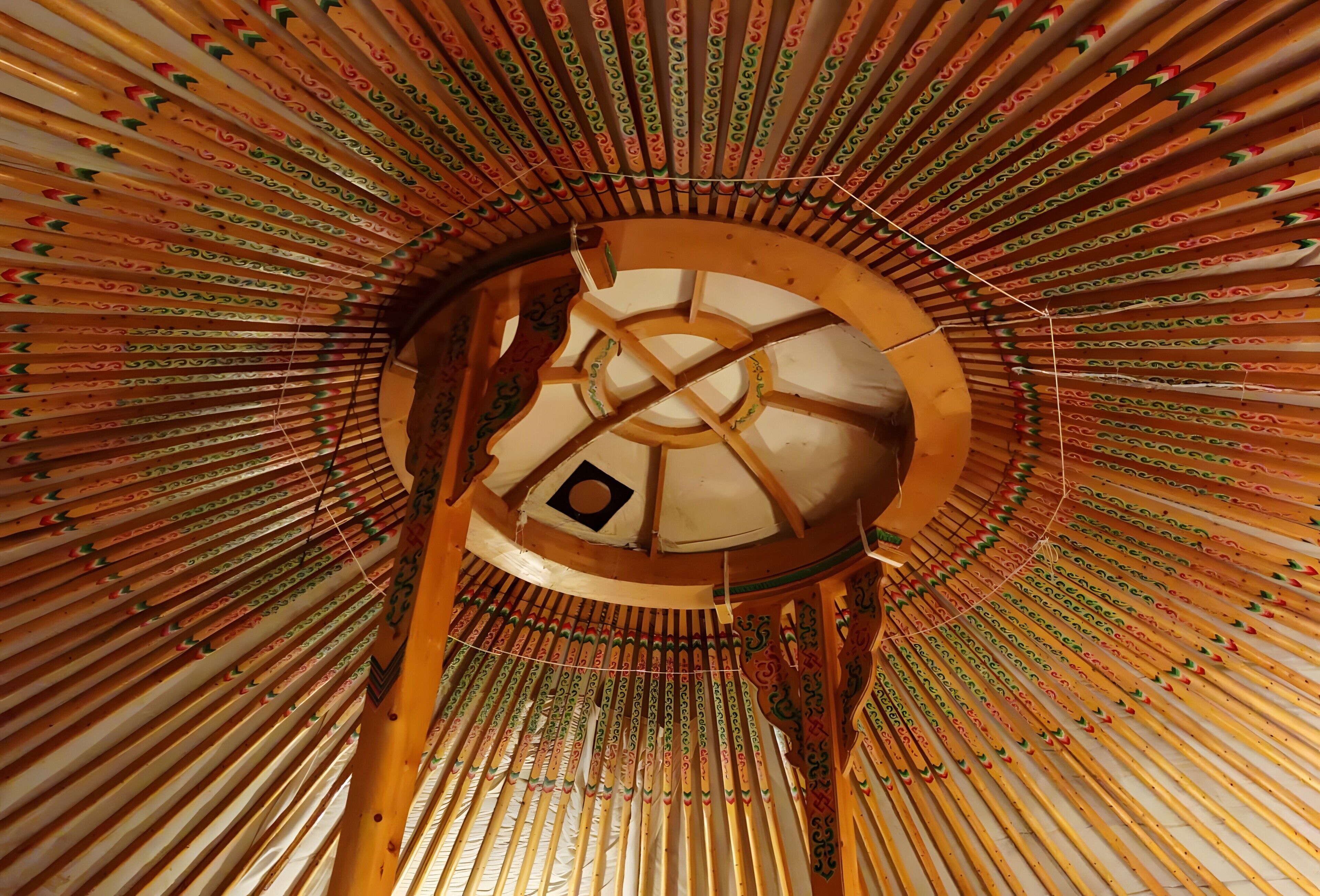 Una estructura arquitectónica circular con una abertura central y elementos de madera que se irradian desde el centro.