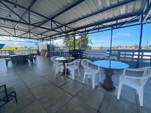 An outdoor patio area with tables and chairs, a grill, and a view of the surrounding neighborhood. - Casa Especial,5 spacious bedroom house with roof top terrace, 20 minutes from SJ (ToaBaja)