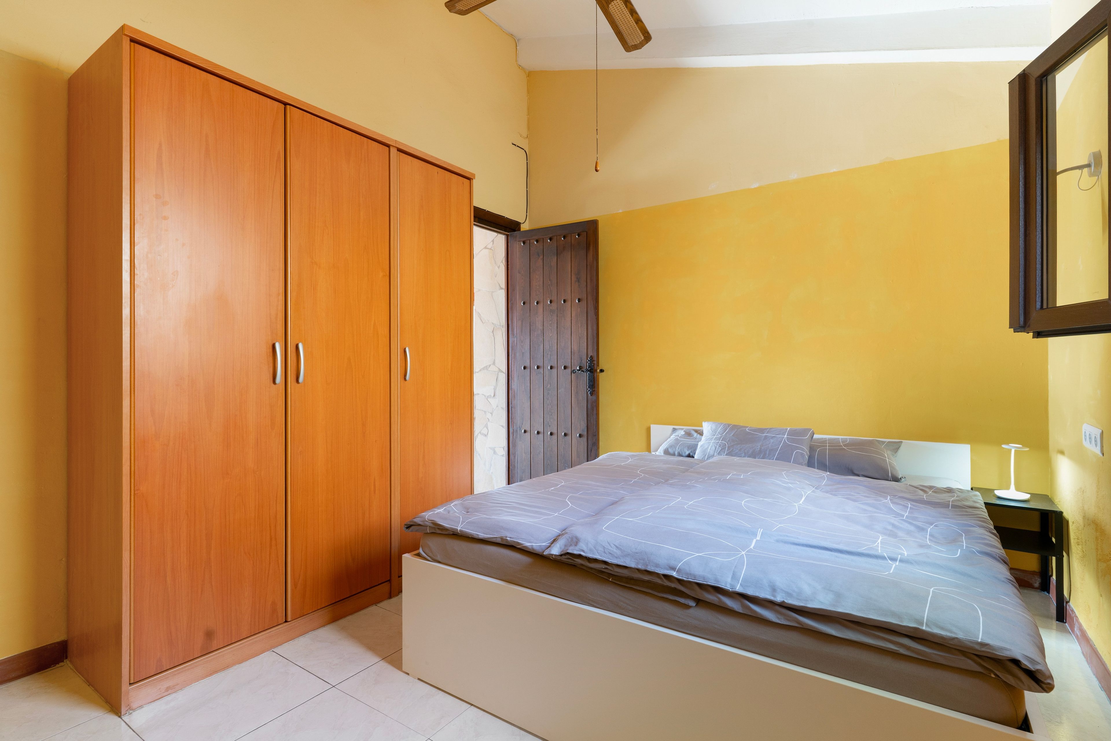Ein Schlafzimmer mit einem Bett, einem Kleiderschrank und einem Nachttisch.