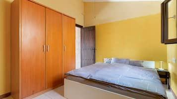 Ein Schlafzimmer mit einem Bett, einem Kleiderschrank und einem Nachttisch.