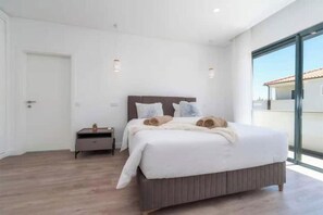 A bedroom with a bed, bedside table, and a view of the outside. - Villa with a private pool, 2 suites, a barbecue, and air conditioning (Albufeira)
