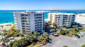 A multi-story hotel with balconies overlooking a beach and ocean. - Gorgeous Inside and Views in East Pass Towers 602 (Destin)