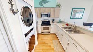 A compact kitchen with a built-in oven, microwave, and a sink. - Perfect Location and Amenities Sandpiper Cove 9126 (Destin)