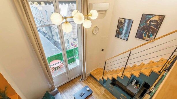 A modern interior with a staircase, a dining area, and a view through large windows. - Pradel - Furnished apartment - Downtown Lyon (Lyon)