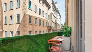 A balcony with a green hedge, a red folding table, and two chairs. - Pradel - Furnished apartment - Downtown Lyon (Lyon)