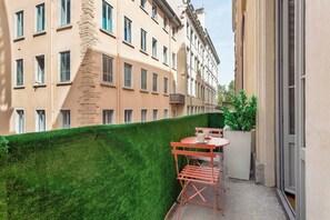 A balcony with a green hedge, a red folding table, and two chairs. - Pradel - Furnished apartment - Downtown Lyon (Lyon)