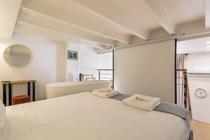 A modern bedroom with a large bed, a bedside table, a mirror, and a view of a balcony. - Pradel - Furnished apartment - Downtown Lyon (Lyon)