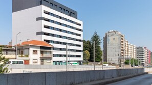 A multi-story building with a flat facade, large windows, and a visible entrance with a covered area. - Elegant 1BR Retreat near Metro by LovelyStay (Vila Nova de Gaia)