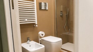 Un bagno con toilette, bidet e doccia.
