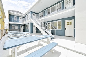 A multi-story building with a balcony, outdoor seating, and a staircase.