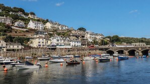 A harbor with boats, a bridge, and houses on a hillside. - Harbourside Retreat (Looe)