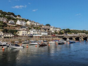 A harbor with boats, a bridge, and houses on a hillside. - Harbourside Retreat (Looe)