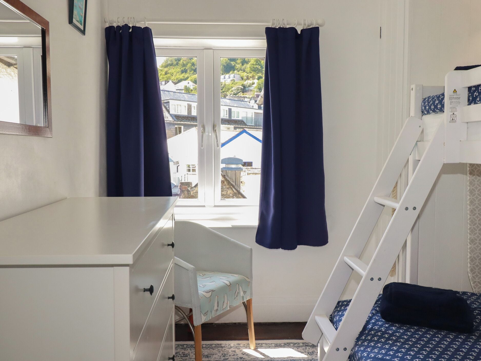 Una habitación con literas, un escritorio y una silla.