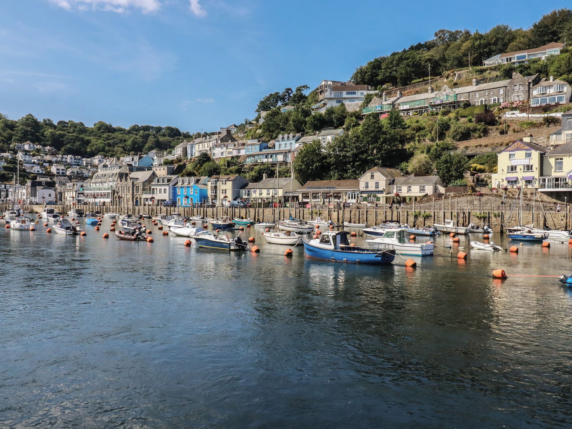 A harbor with boats docked, surrounded by residential buildings.