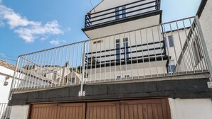 A gated entrance with a metal fence and a brown garage door. - Harbourside Retreat (Looe)
