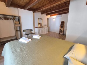 Ein Schlafzimmer mit einem Bett, einem Schminktisch, einem Spiegel und einem Kleiderschrank.