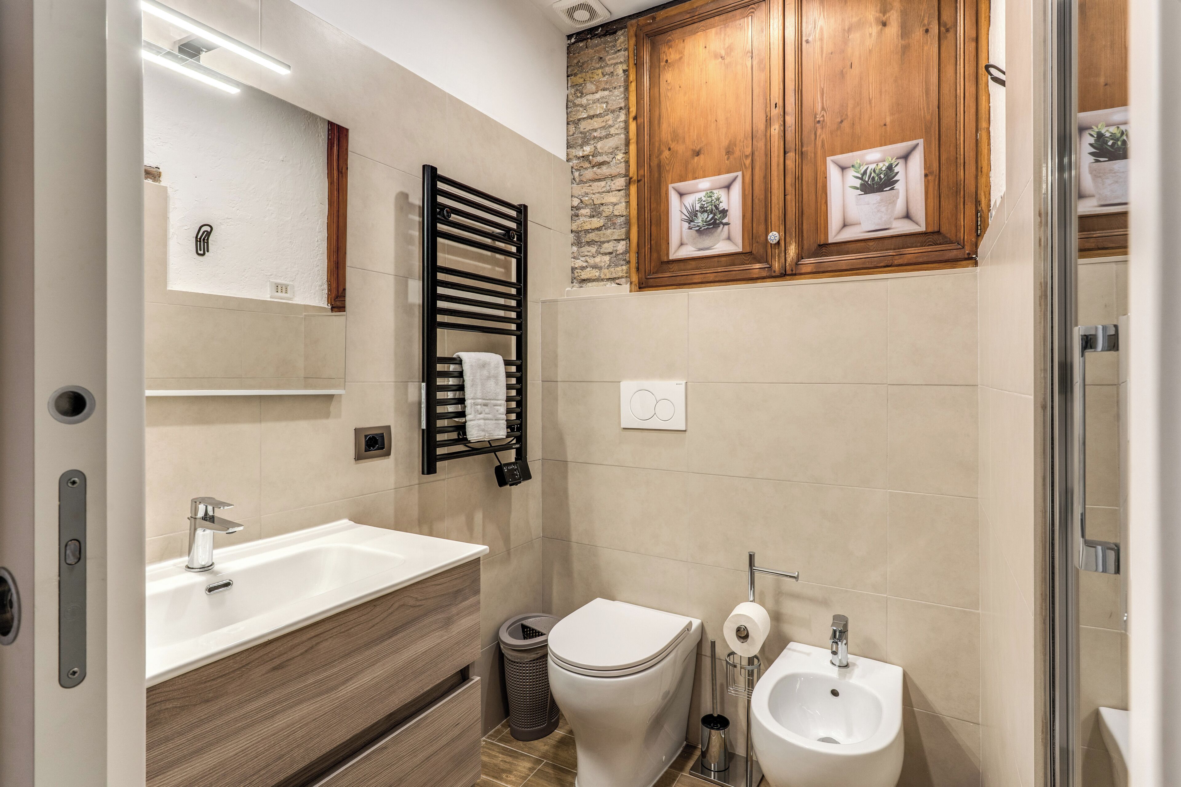Un bagno moderno con lavandino, water, bidet e mobili in legno.