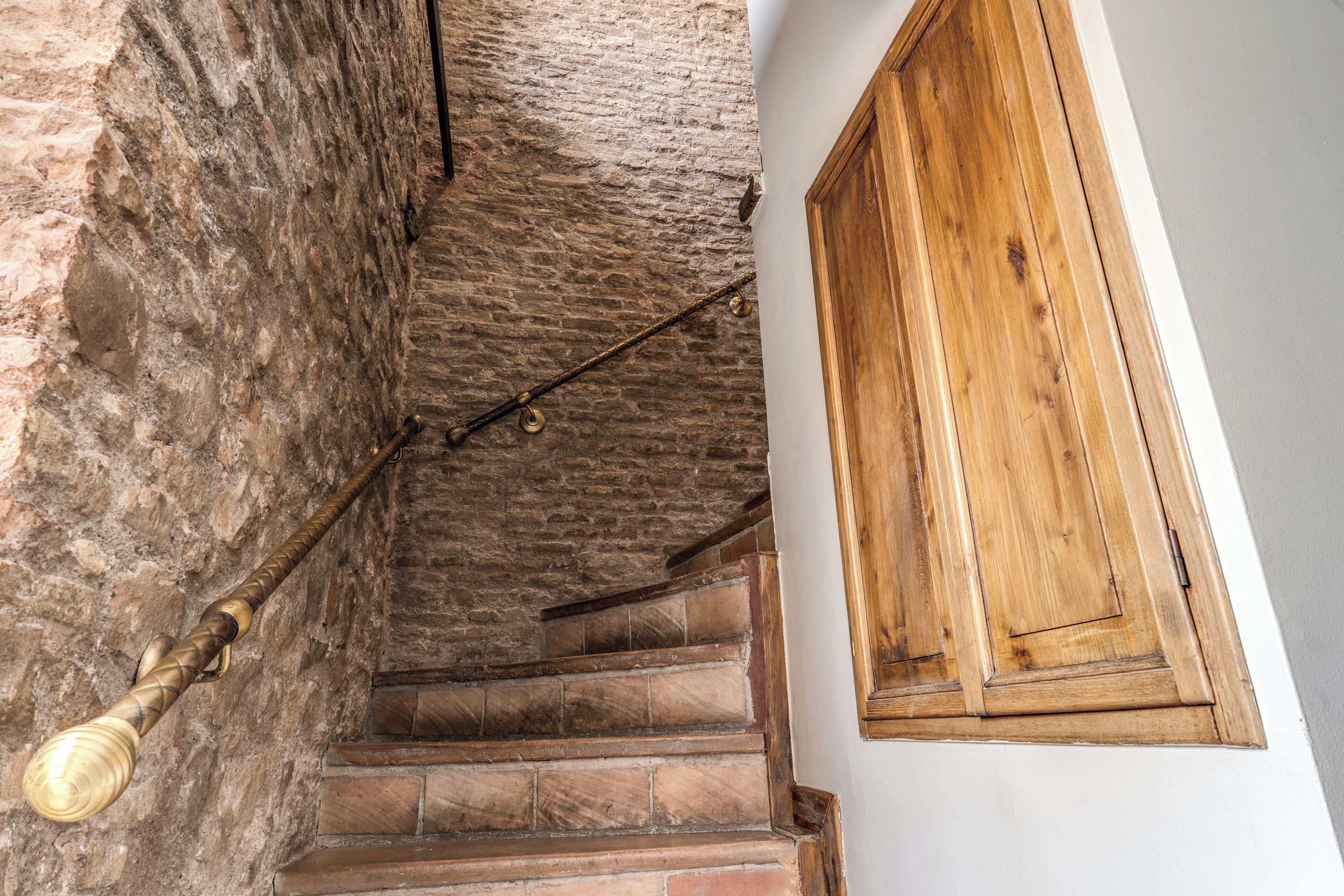 A staircase with stone walls and wooden steps.