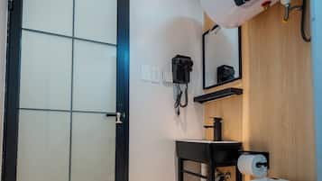 Un baño moderno con inodoro, lavamanos y espejo.