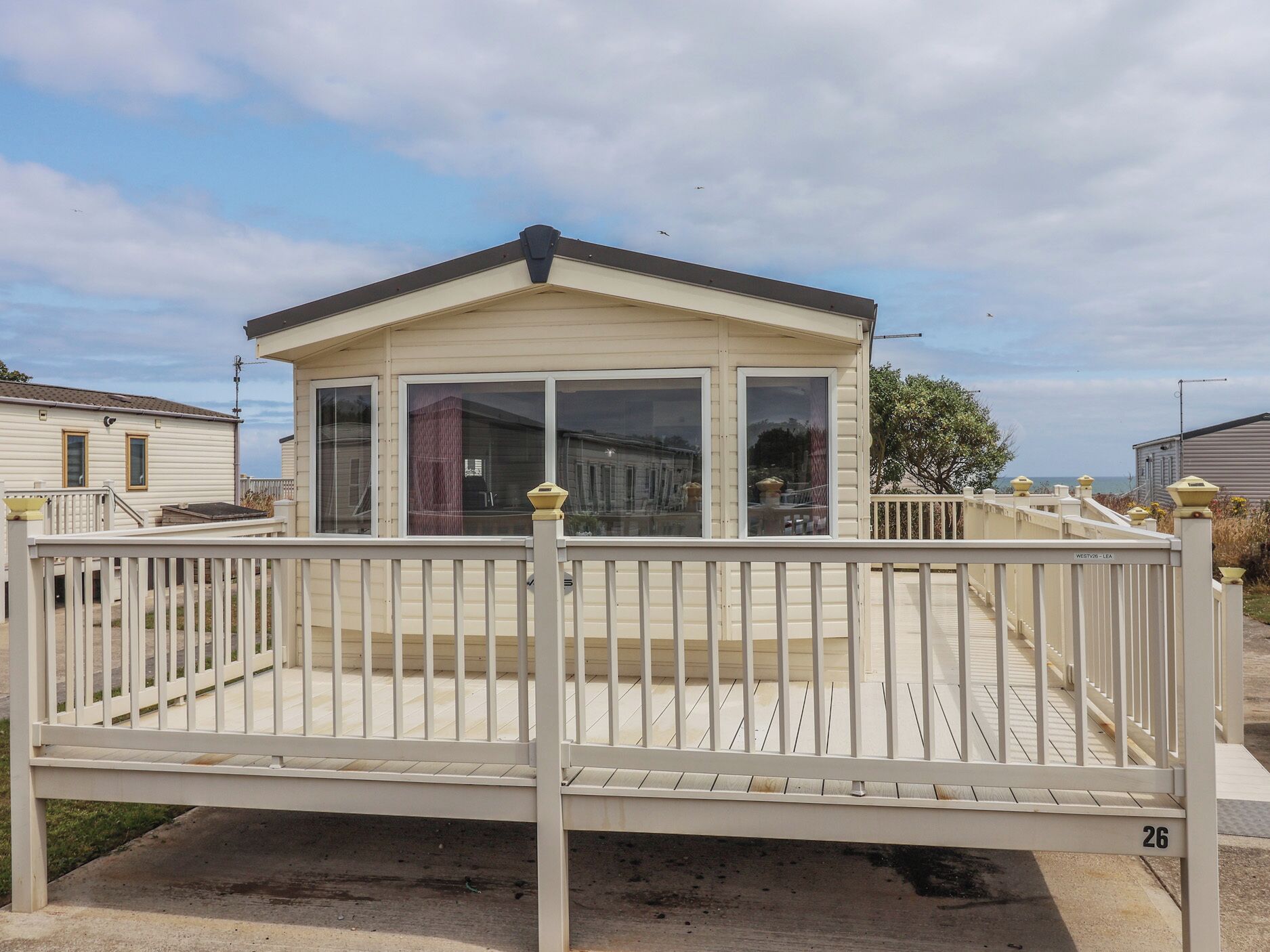 Una casa móvil con un porche cubierto y una terraza cercada.