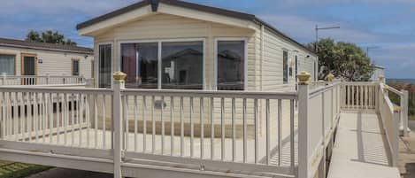 A single-story mobile home with a covered porch and a ramp leading to the entrance.