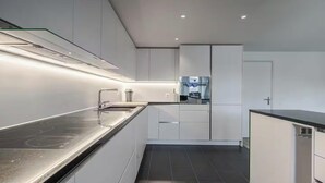 Eine moderne Küche mit Einbauherd, Spüle und Kühlschrank.
