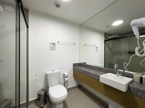 A modern bathroom with a toilet, sink, and shower. - Today Butantã  (São Paulo)
