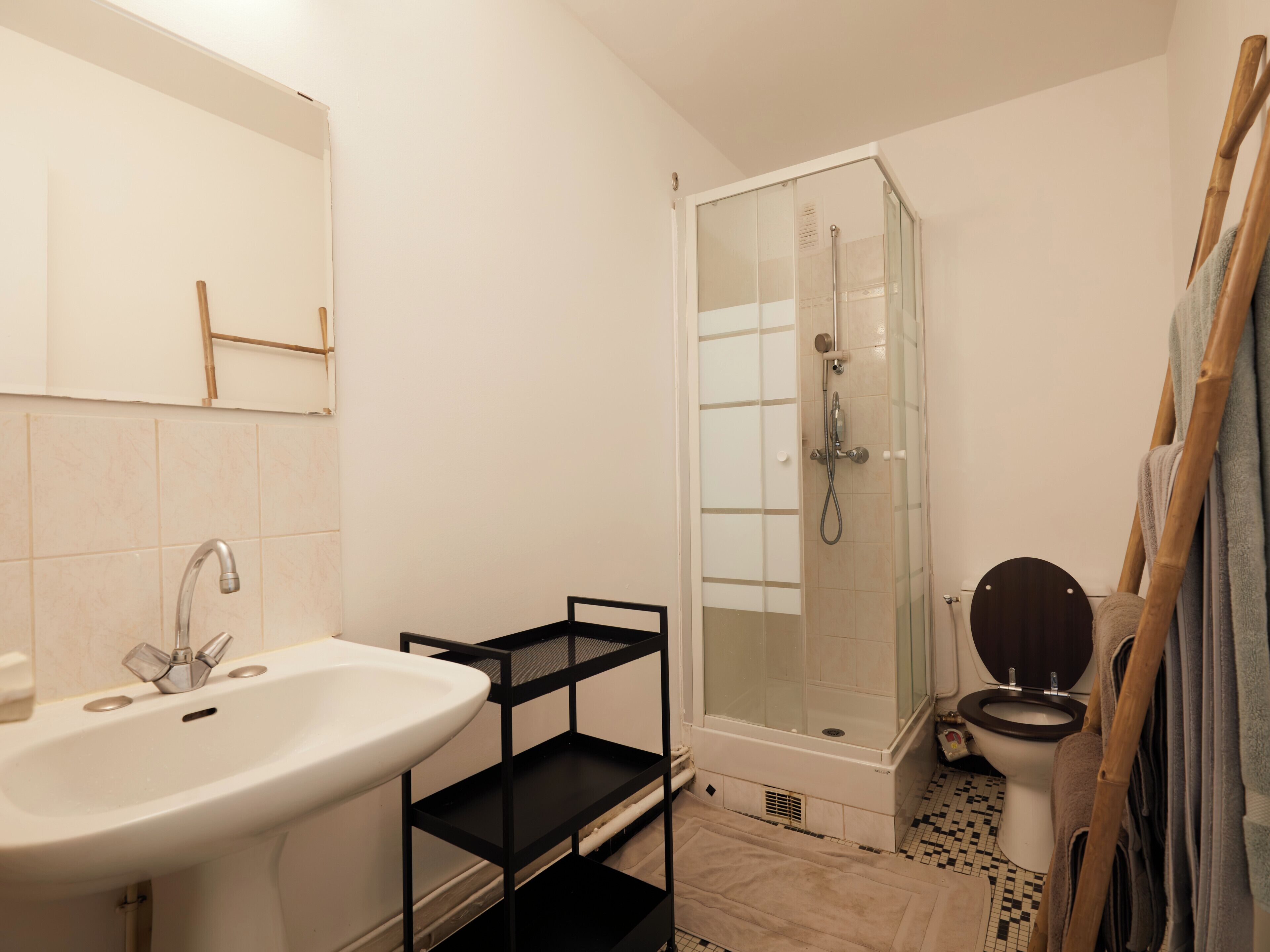 A bathroom with a white sink, a glass-enclosed shower, and a toilet.