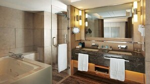 Uma casa de banho moderna com uma banheira, duas pias, um espelho grande e um porta-toalhas.