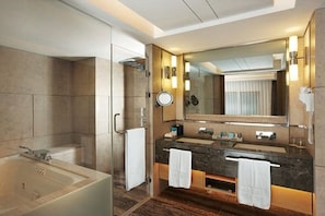 A modern bathroom with a bathtub, two sinks, a large mirror, and a towel rack. - Blue Eyes Hotel and Restaurant (Phnom Penh)