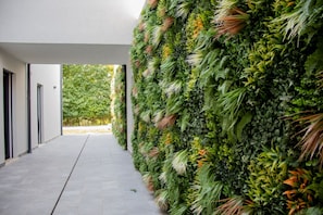 A modern building with a vertical garden wall and a concrete pathway. - A bright and welcoming 50-square-meter apartment, perfect for six people, located on the ground floor of a newly built building.The property is situated in an extremely quiet area and enjoys a strategic location, allowing you to easily visit Valeggio sul (Venturelli-Fenili)