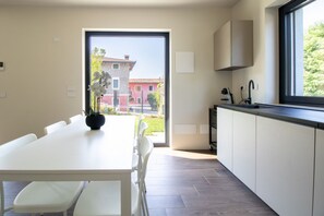 Eine moderne Küche mit Essbereich, einem großen Fenster und Blick auf Gebäude.
