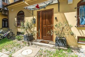 A yellow building with a wooden door, potted plants, a bicycle, and a stone pathway. - A cozy 48 sqm apartment, ideal for up to 3 people, located on the ground floor of a building (accessible via one step).The property enjoys a strategic location, just 700 meters from Porta Nuova station and only 500 meters from the Marconi metro stop.It (Turin)