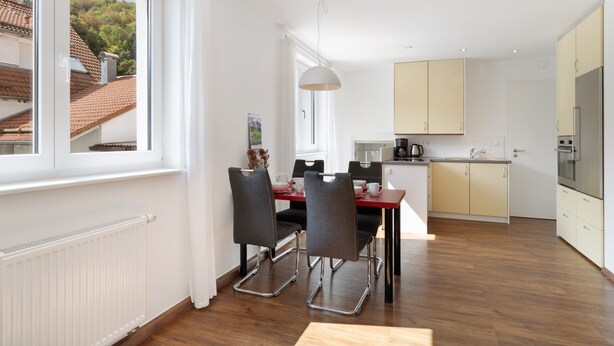 A modern kitchen with a dining area, large windows, and a view of the outside. - Gaiser Apartment, Urach Waterfall, Swabian Alb (Bad Urach)
