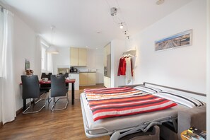 Ein modernes Hotelzimmer mit Bett, Schreibtisch und einer Küchenzeile.