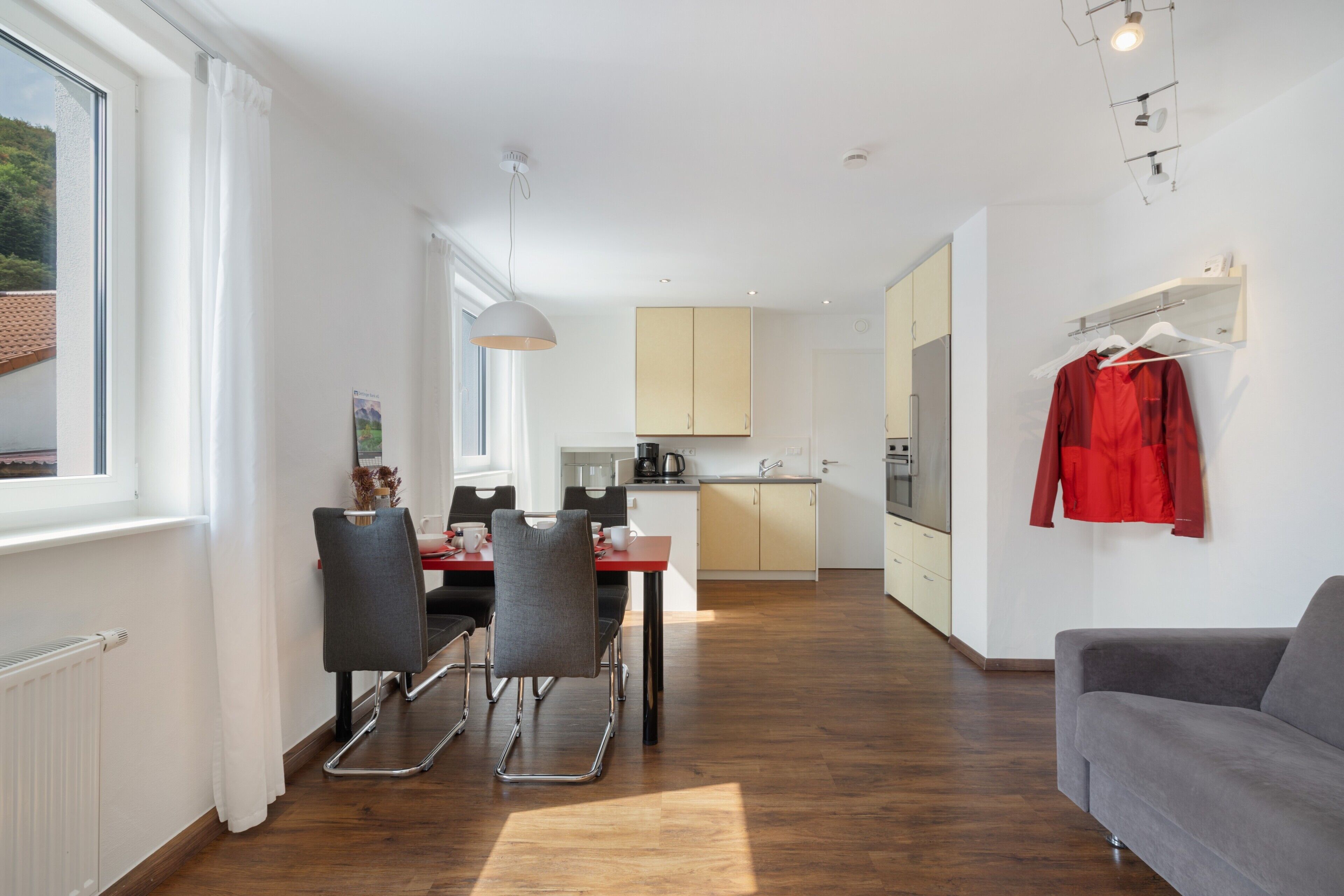 A modern apartment with a dining area, kitchen, and a living room.