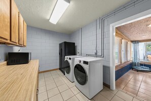 A laundry room with a washing machine, dryer, and microwave. - Be A Nomad | The Seabreeze 5BR Pool House (Jacksonville Beach)