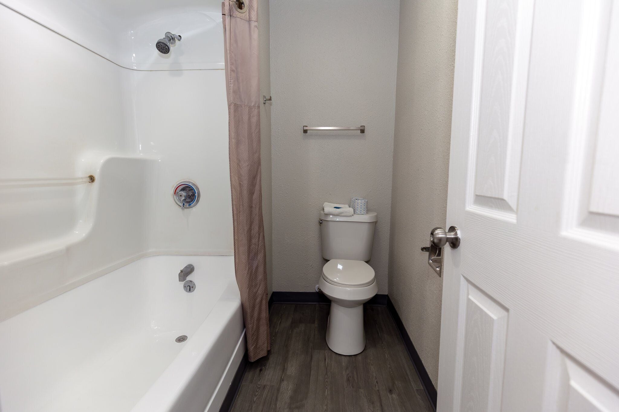 Un baño con bañera, inodoro y cortina de ducha.