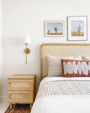 A bedroom with a bed, a bedside table, a lamp, and two framed pictures on the wall. - SOTO: Scottsdale Home, Pool, Spa & Putting Green (Scottsdale)