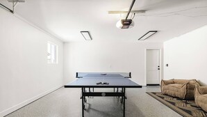 A room with a ping pong table, a door, a patterned rug, and a couch. - LUXE - SOTO Luxury House in Old Town Scottsdale (Scottsdale)