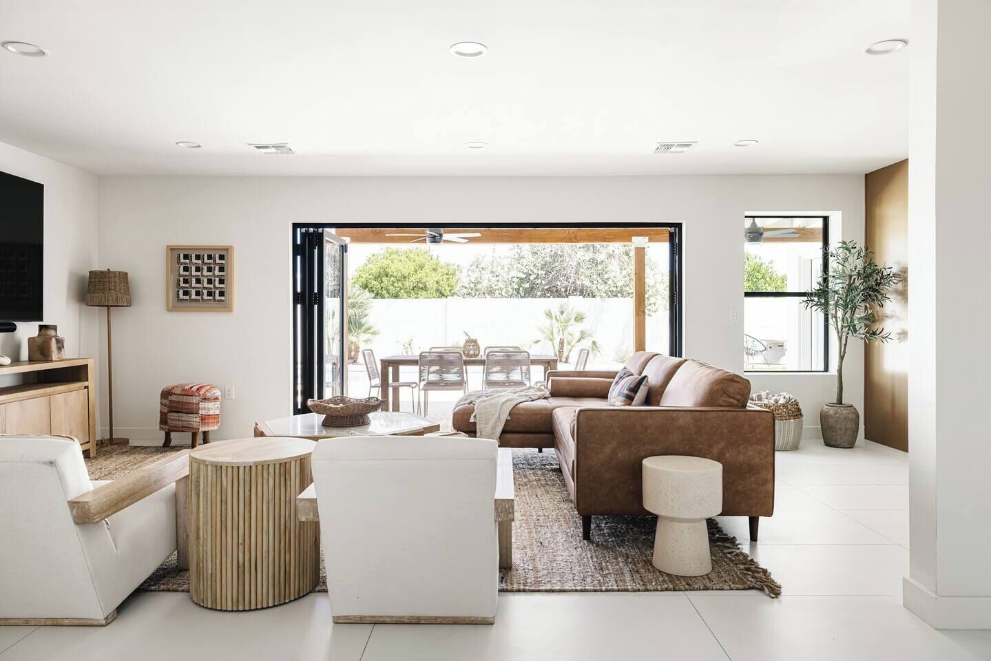 Un salon moderne comprenant un canapé, une table basse et un coin repas avec des chaises.
